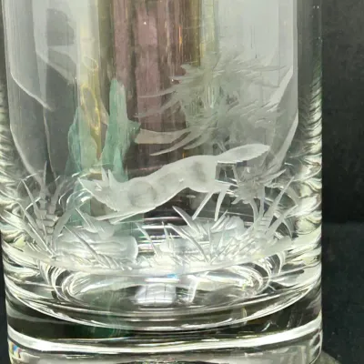 Sale Photo Thumbnail #97: Clear crystal lowball glass featuring detailed etched artwork of a running fox in a natural outdoor landscape.