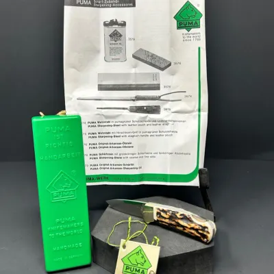 Sale Photo Thumbnail #185: Vintage German Puma folding pocket knife with stag horn handle scale, green plastic sheath, guarantee tag, and original accessories brochure.