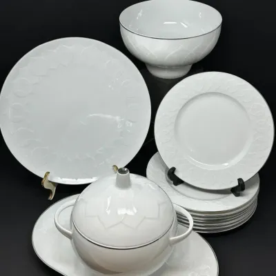 Sale Photo Thumbnail #79:  Rosenthal white porcelain dinnerware set with embossed lotus leaf trim and platinum rimming, including serving pieces, plates, and a covered tureen.