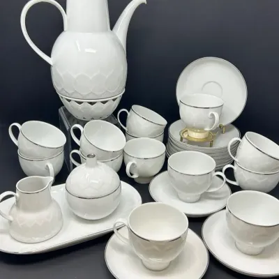 Sale Photo Thumbnail #112: Vintage white porcelain coffee and tea service with silver trim, including a pot with warming base, creamer, sugar bowl, cups, and saucers.