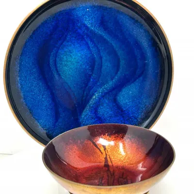 Sale Photo Thumbnail #109: Pair of mid-century enamelled copper art pieces, featuring a round vibrant blue display plate and a small footed fiery orange-red bowl.