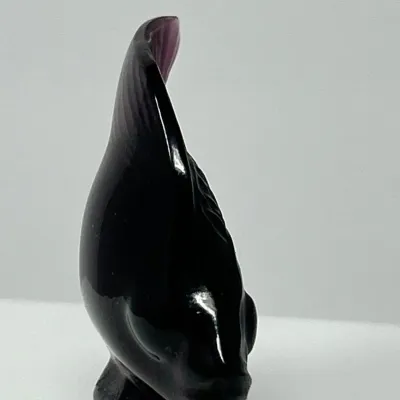 Sale Photo Thumbnail #118: Vintage dark amethyst art glass fish figurine with a sleek, vertical design and subtle purple highlights along the top fin.