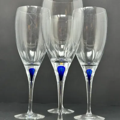 Sale Photo Thumbnail #93: Set of four modern crystal wine glasses featuring cobalt blue teardrop accents encased in slender clear glass stems.