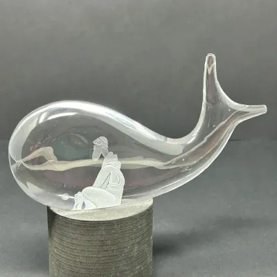 Sale Photo Thumbnail #151: Steuben clear glass 'Jonah and the Whale' paperweight sculpture, featuring an etched figure of Jonah inside the whale, mounted on a round base.