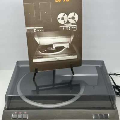 Sale Photo Thumbnail #75: Vintage Revox B795 direct-drive linear-tracking turntable with tinted dust cover and original promotional brochure.