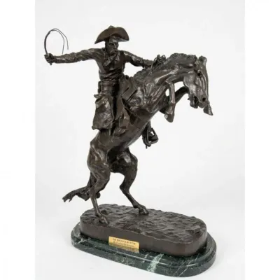 Sale Photo Thumbnail #213: Bronze sculpture reproduction of Frederic Remington's "The Bronco Buster," mounted on a green marble base.