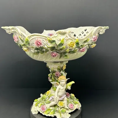 Sale Photo Thumbnail #148: Dresden-style German porcelain reticulated compote center piece featuring applied floral roses and a cherub figure at the base.