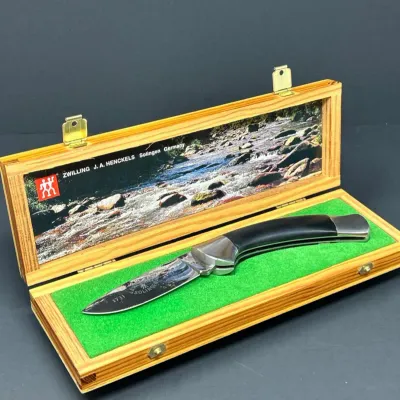 Sale Photo Thumbnail #188: Zwilling J.A. Henckels Solingen Germany folding pocket knife presented in its original wooden display box with a green felt liner.