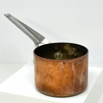 Sale Photo Thumbnail #117: Vintage copper saucepan with stainless steel long handle, showing natural patina and wear on the interior.