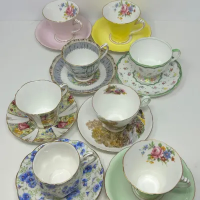 Sale Photo Thumbnail #139: Collection of seven assorted fine bone china teacups and matching saucers featuring various pastel colors and floral patterns with gilded trim.