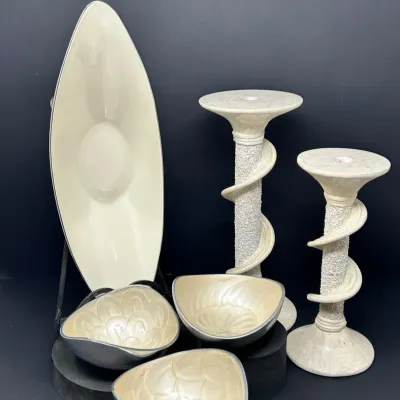 Sale Photo Thumbnail #146: Collection of cream and silver-tone decorative items, including a long marquise-shaped dish, three small textured enamel bowls, and a pair of tall spiral pillar candle holders.