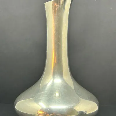 Sale Photo Thumbnail #135: Modernist silver-toned decanter featuring a wide base, slender neck, and an asymmetrical slanted rim.