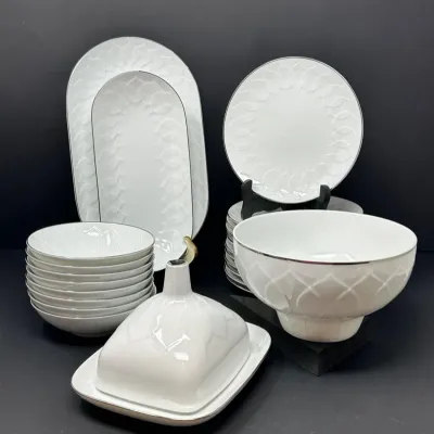 Sale Photo Thumbnail #26: White porcelain dinnerware service featuring raised geometric petal motifs and platinum rim details, including platters, bowls, plates, and a covered dish.