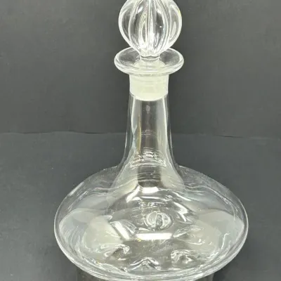 Sale Photo Thumbnail #67: Vintage clear glass wine decanter featuring a wide, squat base and a ribbed spherical stopper.