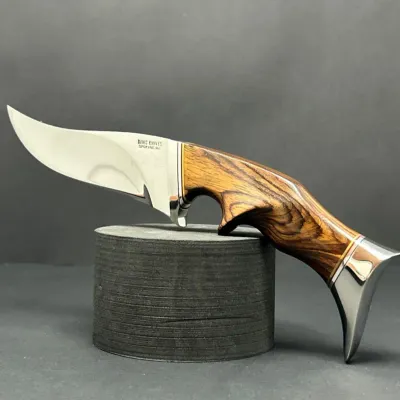 Sale Photo Thumbnail #107: Custom fixed-blade hunting knife by Davis Knives Spokane, WA, featuring a polished steel blade, ergonomic wooden handle, and metal pommel.
