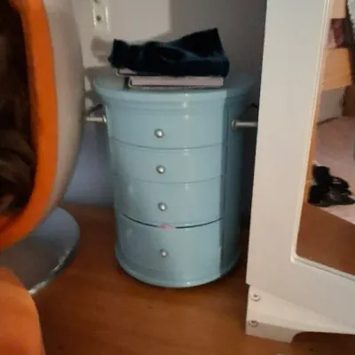 Sale Photo Thumbnail #12: American Girl doll-size light blue metal storage nightstand with four drawers, placed alongside an orange pod chair and an American Girl book.