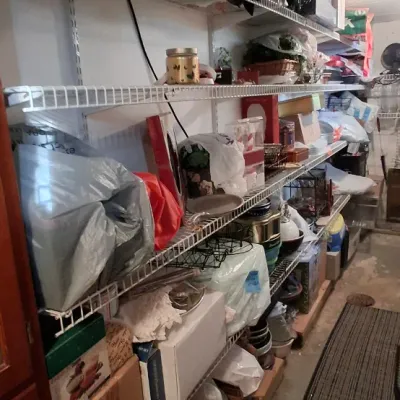 Sale Photo Thumbnail #106: Multi-tier wall-mounted wire shelving units filled with assorted household goods, storage boxes, and kitchen items.