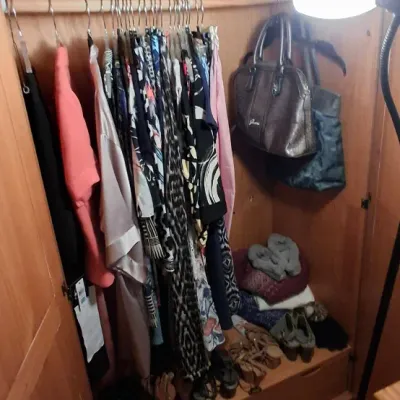 Sale Photo Thumbnail #8: Light oak armoire closet filled with various women's clothing, handbags, and shoes.