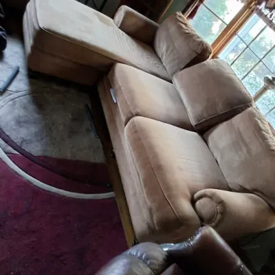 Sale Photo Thumbnail #95: Tan microfiber sectional sofa with an attached chaise lounge, paired with a dark brown leather recliner in the foreground.