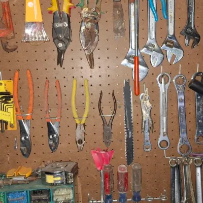 Sale Photo Thumbnail #142: Assortment of vintage and modern hand tools, including pipe wrenches, combination wrenches, pliers, and wire cutters, arranged on a brown pegboard.