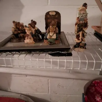 Sale Photo Thumbnail #107: Collection of Boyds Bears resin figurines displayed on a framed glass surface atop a wire shelf, alongside a tall Santa Claus figurine.