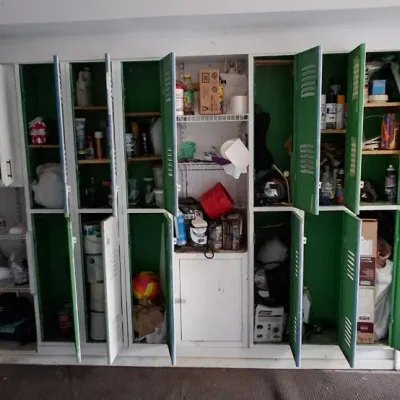 Sale Photo Thumbnail #160: Large garage storage unit featuring tall green metal lockers and surrounding shelving filled with various household and workshop items.