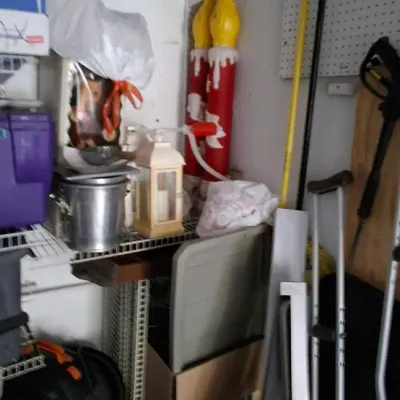 Sale Photo Thumbnail #159: Assorted storage items including large vintage blow-mold candle decorations, metal lanterns, a shop vacuum, and household tools stored on wire shelves and pegboard.