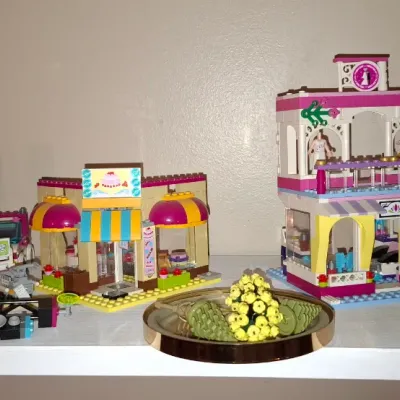 Sale Photo Thumbnail #126: Collection of assembled LEGO Friends playsets including Heartlake Shopping Mall and a bakery, displayed on a shelf.