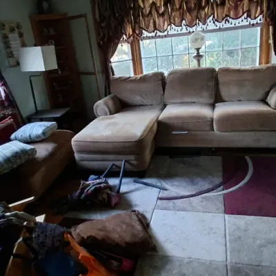 Sale Photo Thumbnail #59: Living room setup featuring a tan sectional sofa with chaise, a dark brown leather recliner, and a geometric area rug.