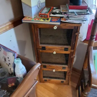 Sale Photo Thumbnail #43: Rustic three-tier wooden cabinet with wire mesh front doors, topped with various crafting supplies and books.