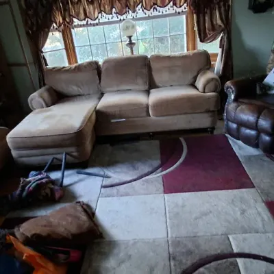 Sale Photo Thumbnail #56: Living room set featuring a beige microfiber sectional sofa with chaise, a dark brown leather recliner, and a geometric color-block area rug.