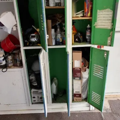Sale Photo Thumbnail #161: Set of four green industrial metal storage lockers filled with various garage supplies and household items.