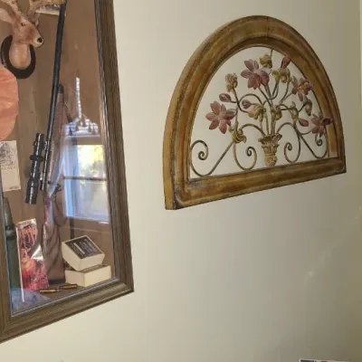 Sale Photo Thumbnail #26: Wooden shadow box frame displaying hunting paraphernalia alongside a semi-circular metal and wood floral wall accent piece.