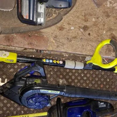 Sale Photo Thumbnail #146: Selection of used power yard tools including a Ryobi cordless string trimmer, leaf blower, and hedge trimmers.