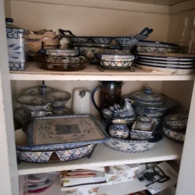 Sale Photo Thumbnail #58: Shelves filled with various hand-painted Mexican Talavera pottery serving dishes, bowls, and platters, along with kitchen household items.