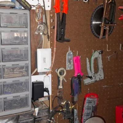 Sale Photo Thumbnail #141: A workshop pegboard organizing system paired with a multi-drawer plastic hardware cabinet filled with assorted small parts and tools.