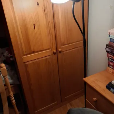 Sale Photo Thumbnail #5: Black metal Torchiere floor lamp with an adjustable reading light, set alongside a tall pine wooden wardrobe cabinet.