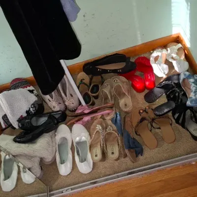 Sale Photo Thumbnail #70: A collection of women's shoes and sandals in various styles, colors, and sizes arranged on the floor.