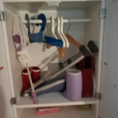 Sale Photo Thumbnail #9: American Girl doll size white wooden armoire wardrobe closet filled with doll accessories, including crutches, a cast, hangers, boots, and books.