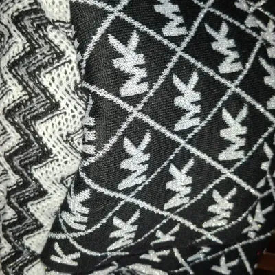 Sale Photo Thumbnail #75: Folded knit garments including a Michael Kors signature monogram sweater and a chevron pattern knit top displayed next to a stack of books.
