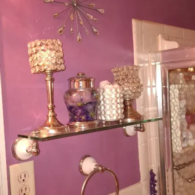 Sale Photo Thumbnail #24: Collection of glam-style bathroom decor featuring crystal-encrusted votive holders, a floral accent jar, and a starburst wall clock displayed on a glass wall shelf.