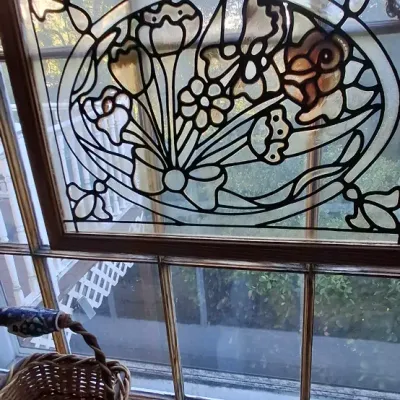 Sale Photo Thumbnail #34: Personalized stained glass window panel reading "Ray and Susan" featuring floral motifs, displayed above woven baskets on a windowsill.