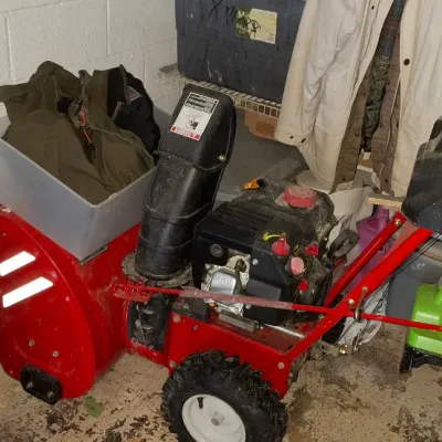Sale Photo Thumbnail #154: Red two-stage gas snowblower with black chute, knobby tires, and a OHV engine.