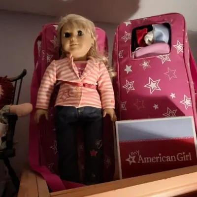 Sale Photo Thumbnail #15: Blonde My American Girl 18-inch doll dressed in a striped jacket and jeans, displayed alongside two pink star-patterned doll carrying cases.