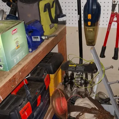 Sale Photo Thumbnail #147: Workshop shelf and pegboard filled with assortment of power tools, hand tools, toolboxes, and gardening equipment.