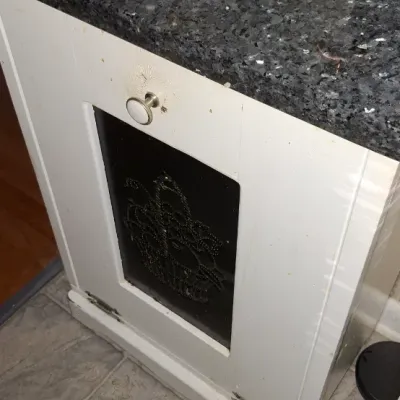 Sale Photo Thumbnail #57: White painted wooden cabinet featuring a polished dark granite top and a tin-punched door insert depicting a basket of fruit.