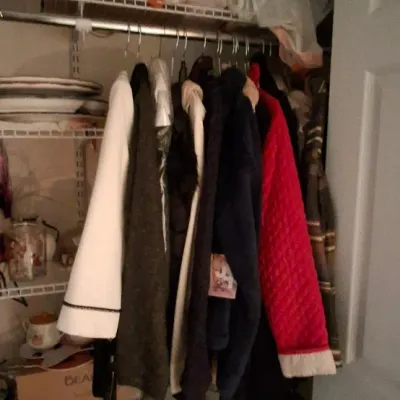 Sale Photo Thumbnail #102: Closet packed with hanging outerwear, plastic storage drawers, and assorted home decor on wire shelving.