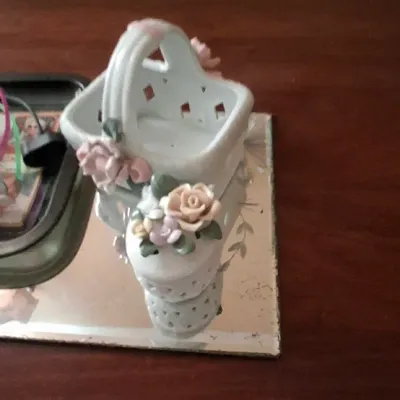 Sale Photo Thumbnail #84: Vintage white porcelain pierced basket trinket dish adorned with applied pastel ceramic roses, resting on a small mirrored vanity tray.