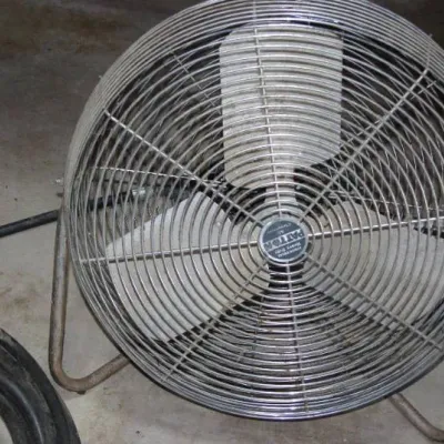 Vintage Patton high-velocity industrial floor fan with metal blades and chrome wire guard.