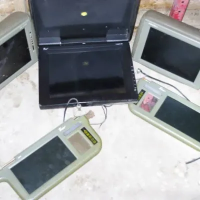 Collection of vintage aftermarket car video electronics, including headrest monitors, a flip-down DVD player screen, and sun visor LCD...
